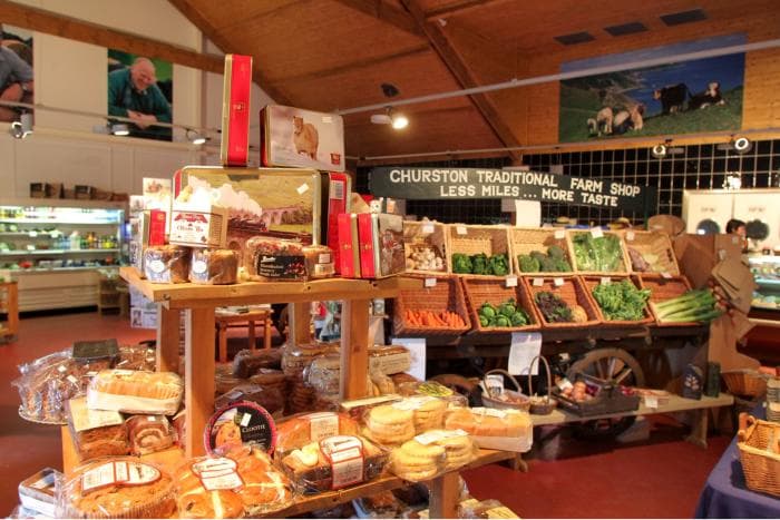 Bakery stands and biscuit tins on the shop floor, with the produce cart behind