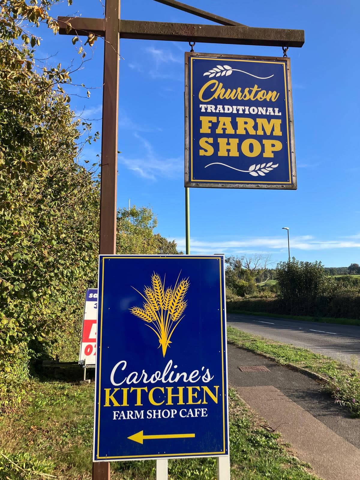 The Churston Traditional Farm Shop and Caroline's Kitchen signs against a blue South Devon sky